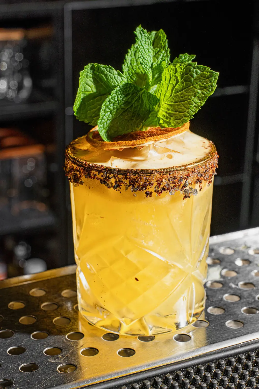 Signature cocktail with a spiced rim and fresh mint