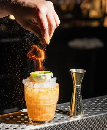 Bartender flaming a citrus garnish